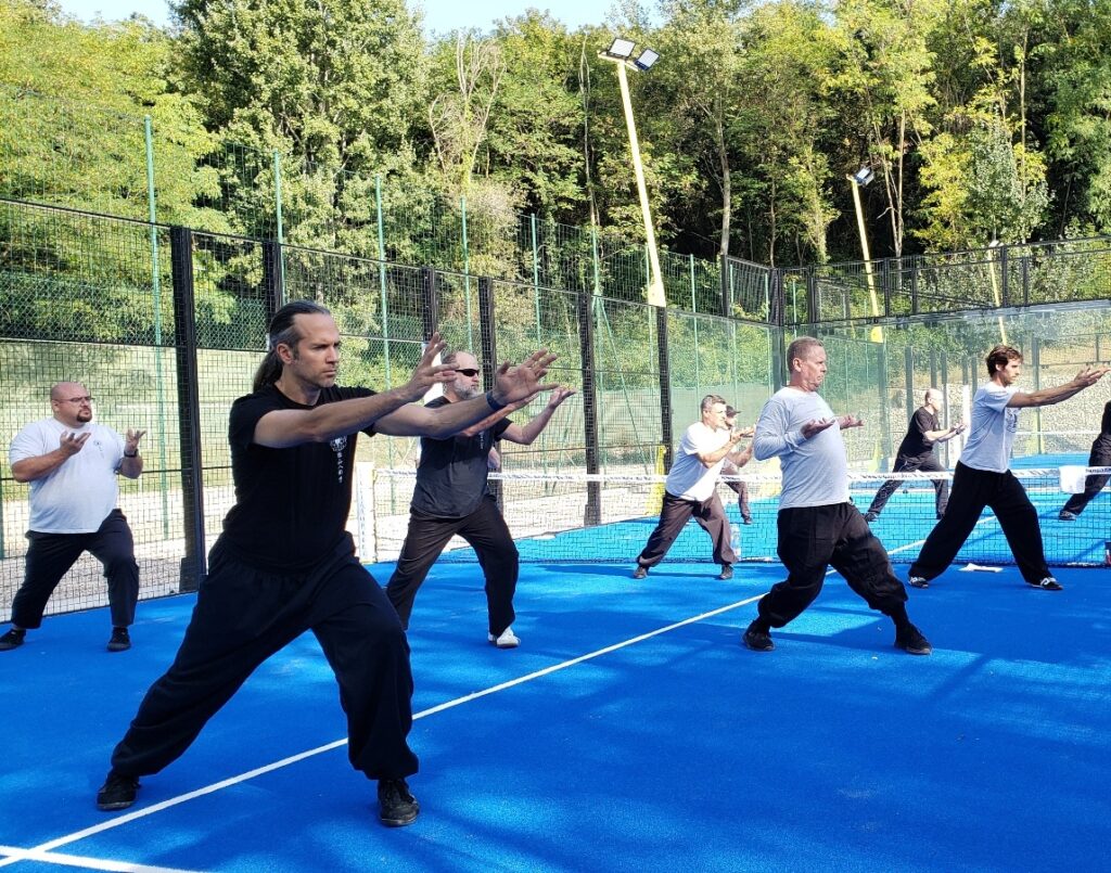 A group practicing qi gong together outdoors